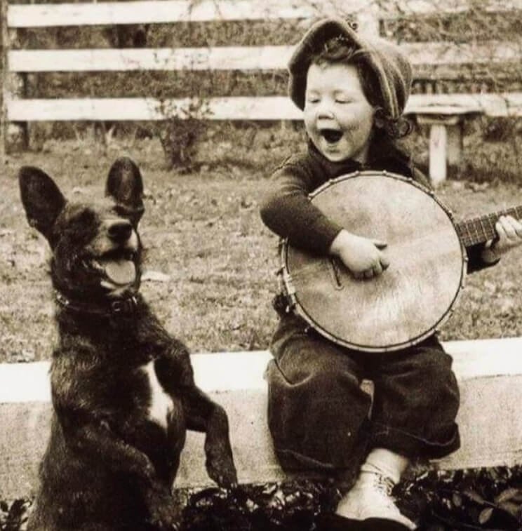Just a Boy, His Banjo, and His Best Friend: A Timeless Snapshot from the 1920s